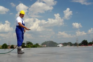 Worker watering concrete slab