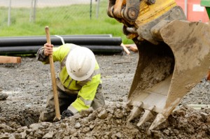 Working digging next to excavator 