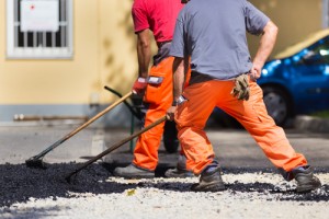 Workers compacting asphalt